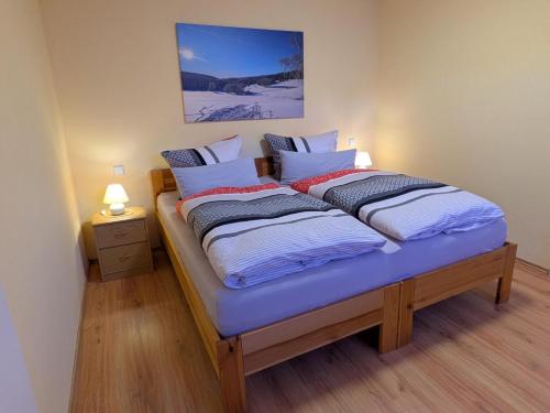 a bedroom with a bed with two pillows on it at Ferienwohnung Am Apelsberg in Neuhaus am Rennweg