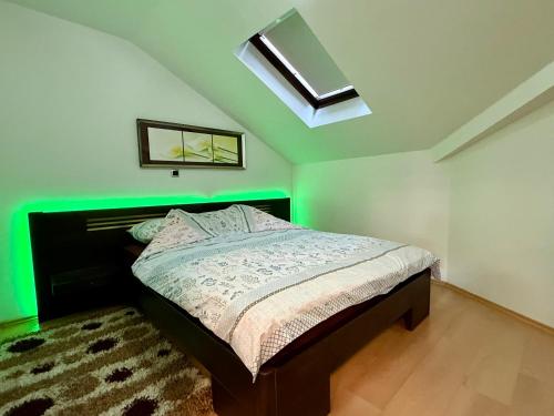 a bedroom with a bed with a green light at Lambada Penthouse in Bugojno