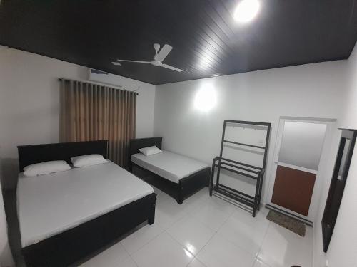 a bedroom with two beds and a mirror in it at Hotel Sanhida Polonnaruwa in Polonnaruwa