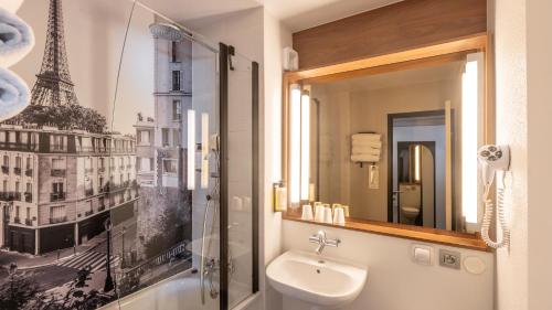 a bathroom with a shower with a sink and a mirror at Campanile PRIME - Paris Bobigny in Bobigny