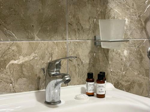 a bathroom sink with two bottles on it at Guesthouse P&A in Budva