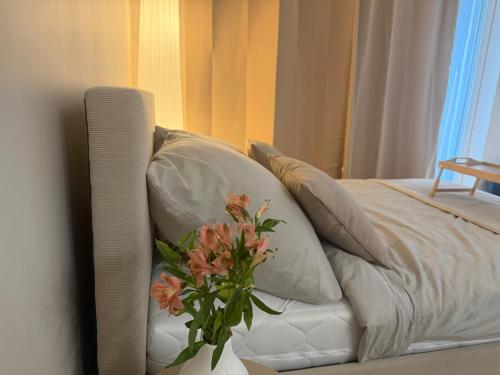a white couch with a vase with flowers on it at Mazury Mood kawalerka studio in Giżycko