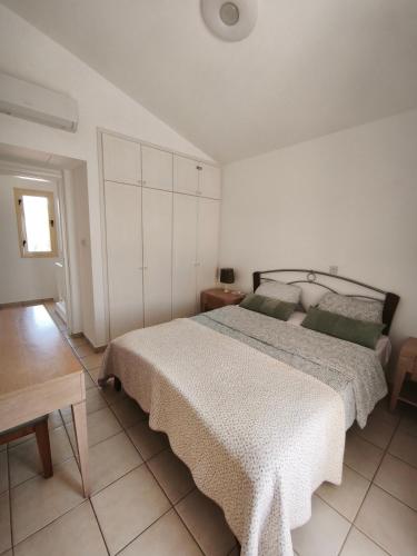 a bedroom with a large bed and a table at Eden gardens in Paphos