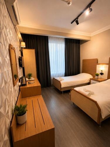 a hotel room with two beds and a table at OTEL MOLA BALIKESiR in Balıkesir