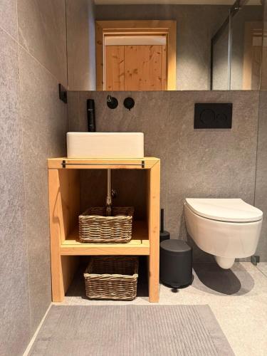 a bathroom with a toilet and a shelf with baskets at Il Fienile di Ebbe in Bormio