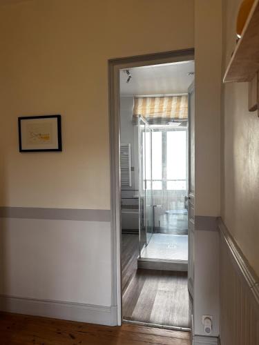 a glass door leading into a room with a bathroom at Chez Marie in Dunkerque
