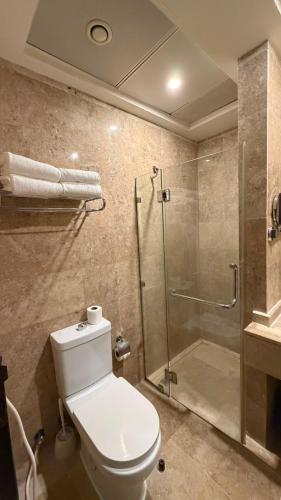 a bathroom with a toilet and a glass shower at Saif Al Majd Hotel in Mecca