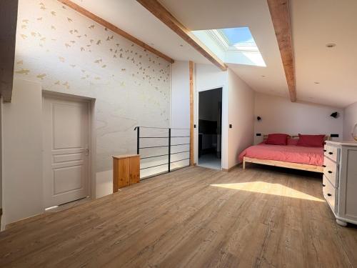a bedroom with a red bed and a skylight at L'échappée verte in Chirens