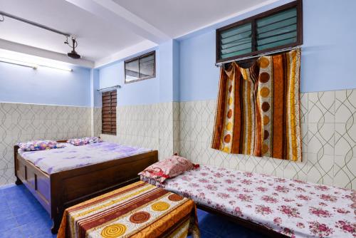 a bedroom with two beds and a window at Hotel Alankar Lodge Kharagpur in Kharagpur