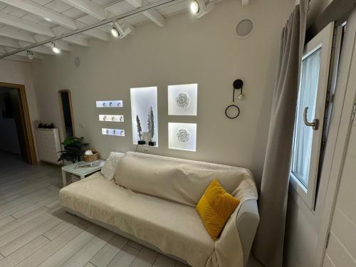 a living room with a couch with yellow pillows on it at Ano Syros Orient in Ano Syros