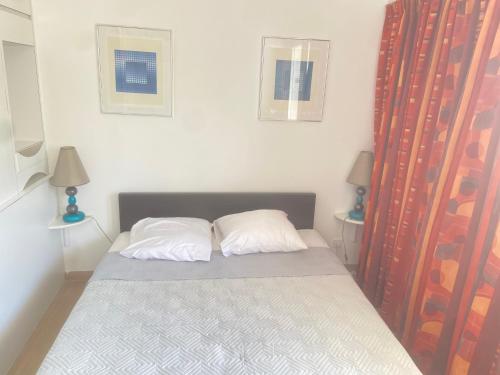 a bedroom with a bed with two pillows at Studio avec piscine et grande terrasse Parking gratuit Nice in Nice