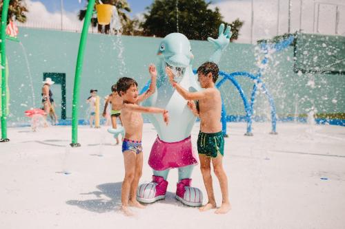 two boys playing with a inflatable person on a water park at Maspalomas Resort by Dunas in Maspalomas