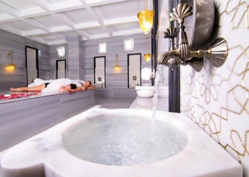 a bathroom with a bath tub with a sink at LRS Hotels Port River Hotel & Spa - Ultra All Inclusive in Side