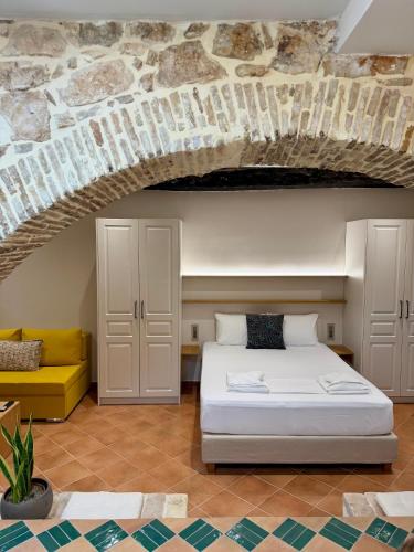 a bedroom with a white bed and a yellow couch at Corcyra Collection in Corfu