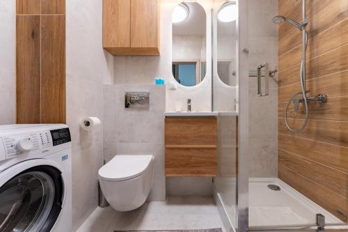 a bathroom with a washing machine and a sink at Rumia Stylish Apartment by BookingHost in Rumia