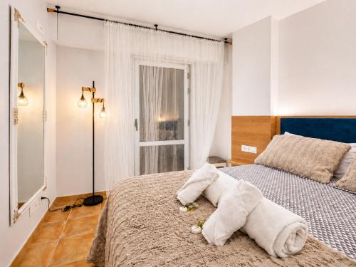a bedroom with a bed with a towel animal on it at Apt. Xaramiños Galitrips in Corcubión