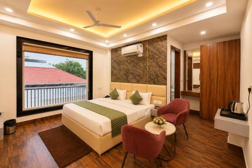 a hotel room with a bed and a balcony at Mazestic Bay Hotel & Banquet in Noida