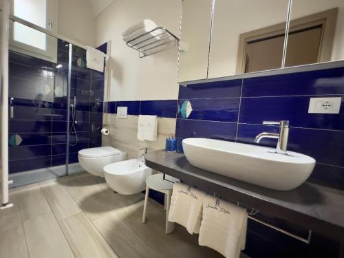 a bathroom with a sink and a toilet and a mirror at Blu costiera Casa Vacanze in Maiori