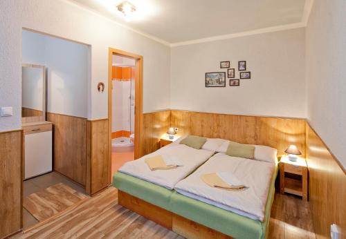 מיטה או מיטות בחדר ב-Wellness Penzión Rosnička