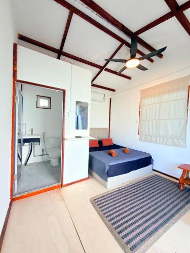 a bedroom with a bed and a bathroom with a sink at Scuba Buddy Mabul Dive Lodge in Pulau Mabul 