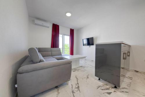 a living room with a couch and a television at MEMO's DUKAT in Šušanj