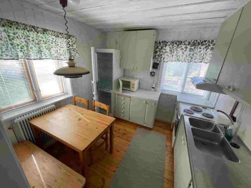 a kitchen with a wooden table and a table and a dining room at Bagarstugan in Älvdalen