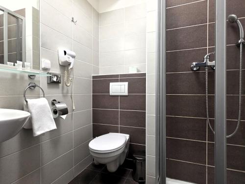 a bathroom with a toilet and a sink at Hotel Centrum Brno in Brno