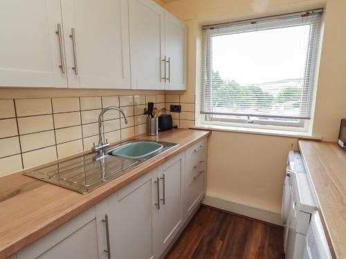 a kitchen with a sink and a window at Flodden Apartment in Wooler