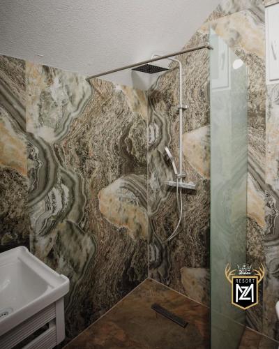 a bathroom with a shower and a sink at Resort Maja e Zezë in Gnjilane
