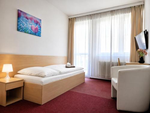 a hotel room with a bed and a window at Hotel Centrum Brno in Brno