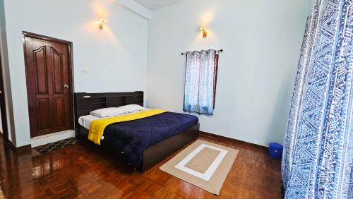 a bedroom with a bed with a yellow blanket at La Parshwa Villa Maré in Mahabalipuram