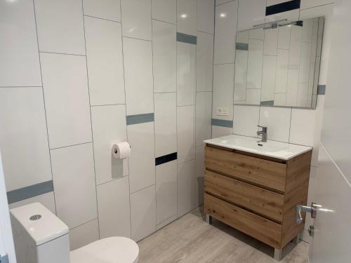 a bathroom with a toilet and a sink and a mirror at Casa la Perla Solo adultos in Béznar