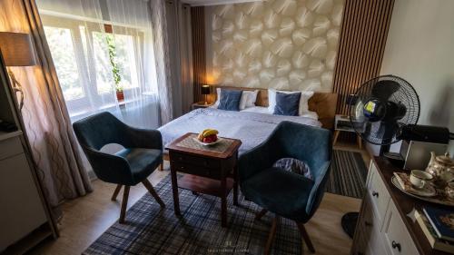 a bedroom with a bed and two chairs and a table at Modern in Zgorzelec