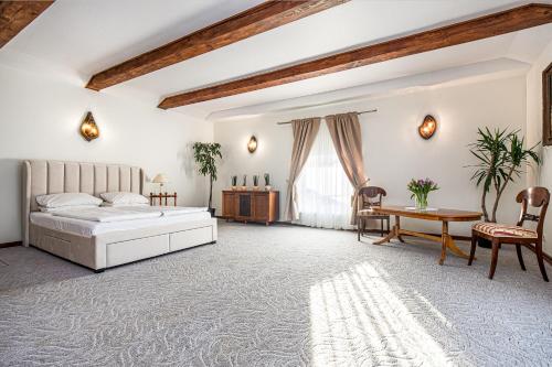 a bedroom with a bed and a table and chairs at Virkštininkų kurortas in Vydmantai
