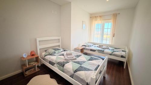 a bedroom with two beds and a window at RIVABeach House in Lourinhã