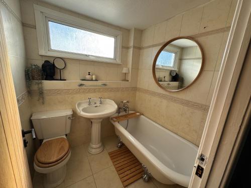 a bathroom with a sink and a tub and a toilet at Nordic Spa House in Brandon