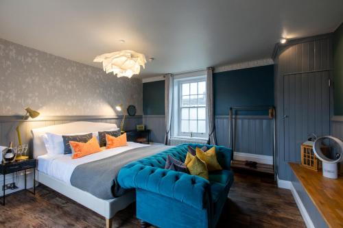 a bedroom with a large bed and a blue couch at The Bull in Ditchling