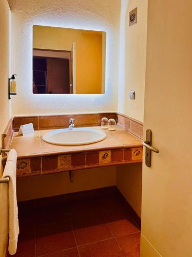 a bathroom with a sink and a large mirror at Lam Hotel Foya Branca in São Pedro