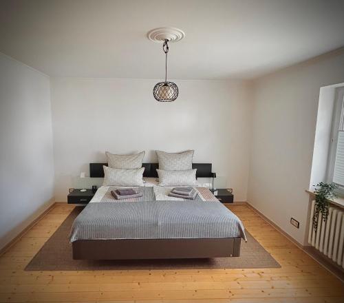 a bedroom with a bed and a pendant light at Rebenlaub in Heringen