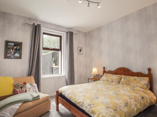 a bedroom with a bed and a window at Keepers Cottage in Peterhead