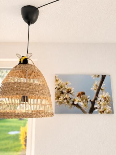 a birdhouse hanging from a ceiling with a picture of a tree at Ferienwohnung Bienenkörbchen in Barge