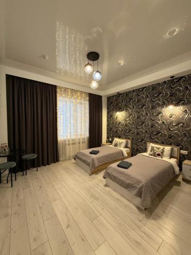 a large bedroom with two beds and a table at Zest hotel & spa in Oral