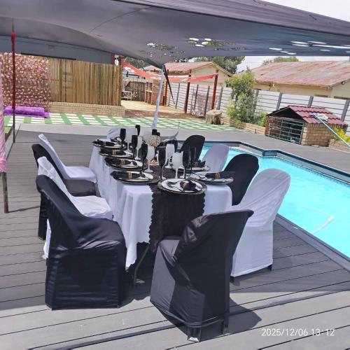 a table set up for a party in front of a pool at Moonlight Guesthouse in Bloemfontein