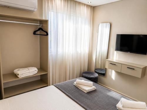 a hotel room with a bed and a flat screen tv at Katsanikos Apartments in Prinos
