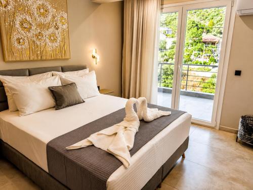 a bedroom with a bed with towels on it at Katsanikos Apartments in Prinos