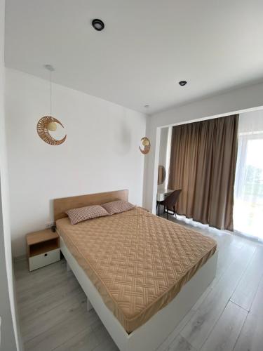 a white bedroom with a large bed and a window at SF Residence in Bosteri