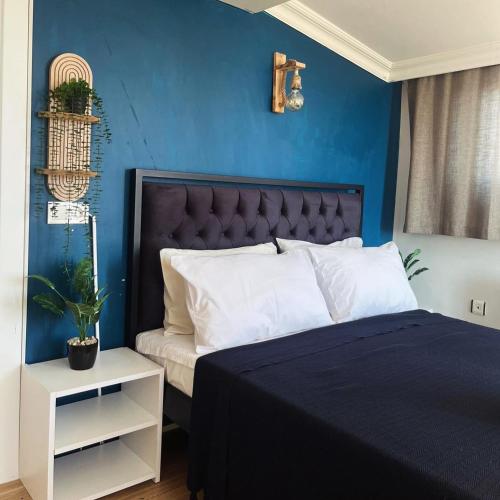 a bedroom with a bed with a blue wall at Blue Sea Hotel in Tuzla