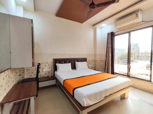 a bedroom with a bed and a large window at Hotel Sagar Residency in Panvel