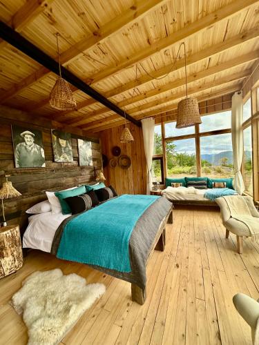 a bedroom with a large bed in a wooden room at Alto Castillo Lodge in Villa Cerro Castillo