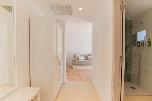 a hallway leading to a living room with a couch at Hotel Cala Dor - Adults Only in Cala d´Or